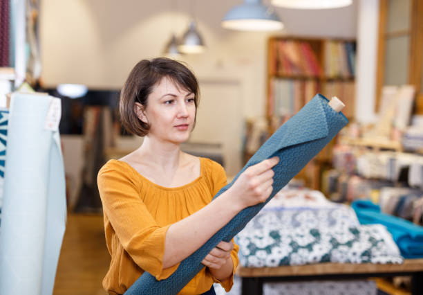 istock Brunette choosing fabric in store 1136776186
