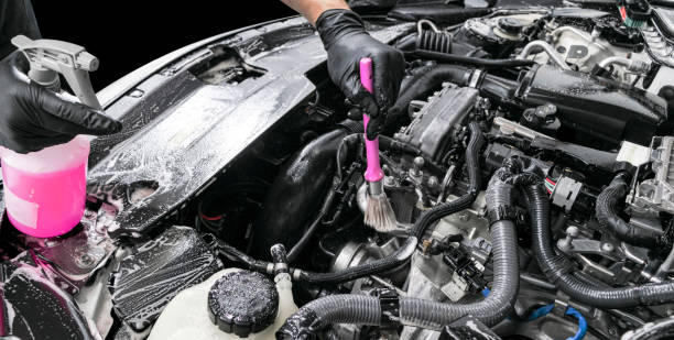 istock A man cleaning car engine with shampoo and brush. Car detailing or valeting concept. Selective focus. Car detailing. Cleaning with sponge. Worker cleaning. Car wash concept solution to clean. Isolated 1136777035