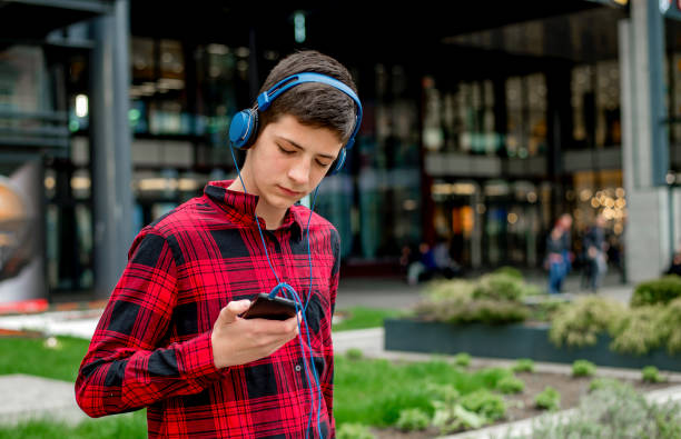 Teen boy listening music with headphones stock photo