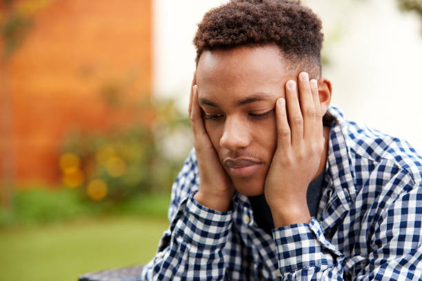 istock Depressed young black man with head in hands, close up, head and shoulders 1136779265