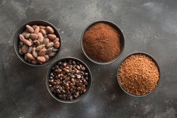 concetto di cacao e chicchi di caffè in ciotole al buio. - coffee crop bean seed directly above foto e immagini stock