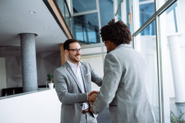 istock Diverse male employees shaking hands in hallway 1136780015
