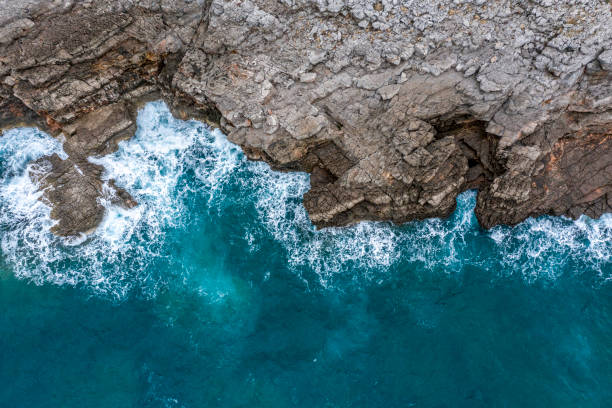 istock Rocky cliff emerging from sea waves 1136781157
