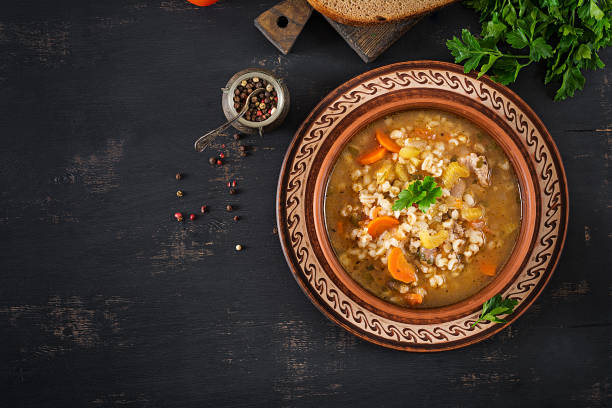istock Barley soup with carrots, tomato, celery and meat on a dark background. Top view. 1136782213