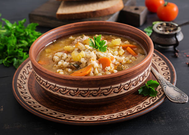 istock Barley soup with carrots, tomato, celery and meat on a dark background. 1136782224