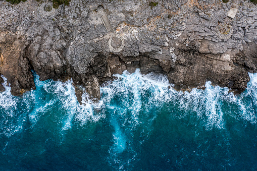 Over the top view of a rocky coastal area extending from the sea.