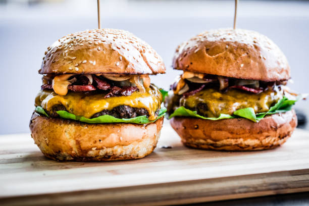 istock Freshly flame grilled bacon cheese burgers in a row 1136786436