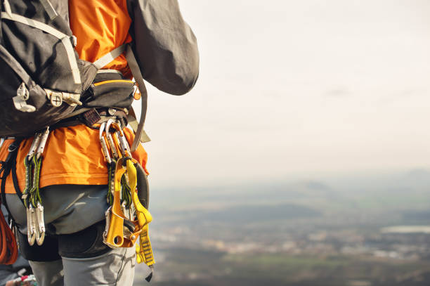 Close-up of a thigh climber with equipment on a belt, stands on a rock stock photo