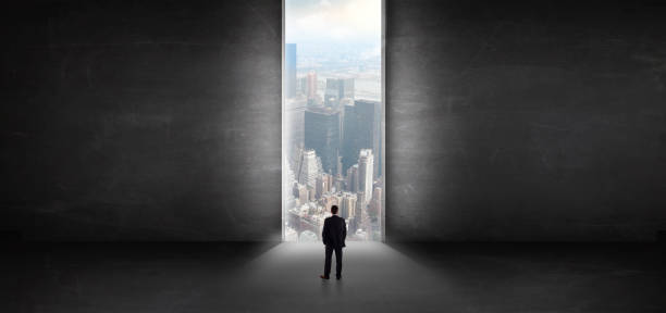 istock Businessman looking to a cityscape from a dark empty room 1136787861