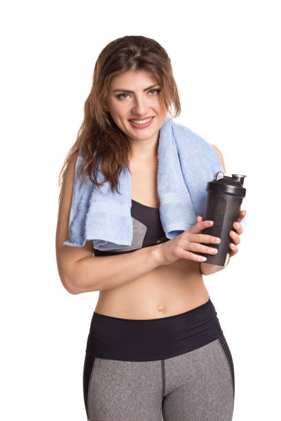 istock Young athletic smiling woman with a shaker and a towel. 1136788084