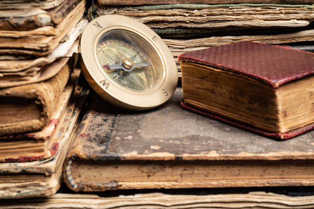 istock Compass On Stack Of Antique Hard Cover Books 1136788740