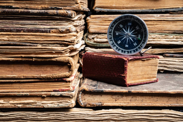 istock Compass On Stack Of Antique Hard Cover Books 1136788741
