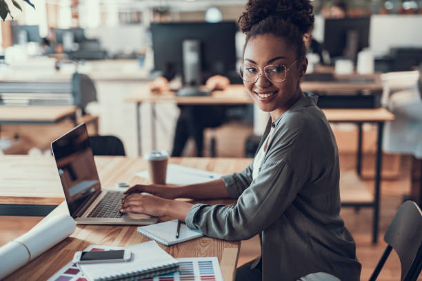 istock Charming afro american girl using laptop at work 1136789079