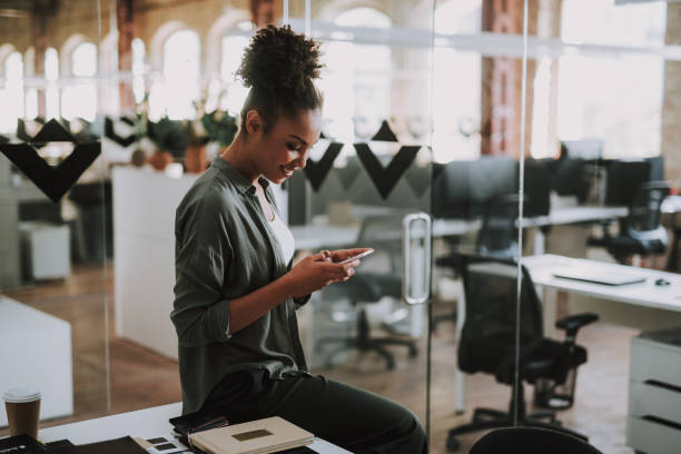 istock Beautiful afro american girl using cellphone at modern office 1136789160