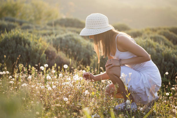 Unrecognizable Caucasian young woman picking flowers.