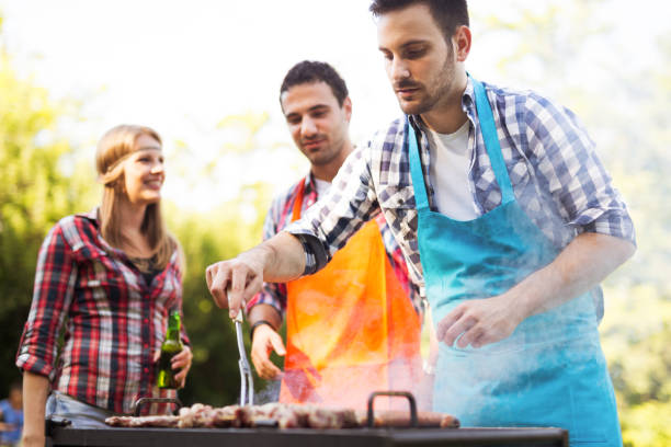 istock Young people grilling outdoors 1136789742