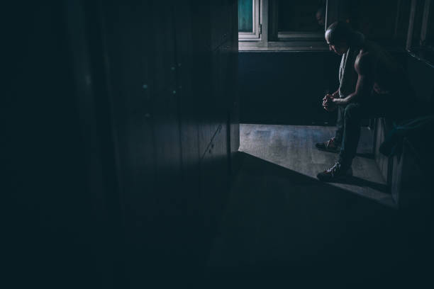 istock Guy sitting in dark locker room in gym 1136791045