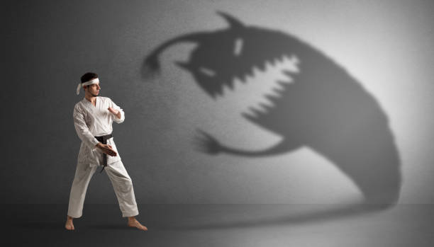 istock Karate man fighting with a big scary shadow 1136791363
