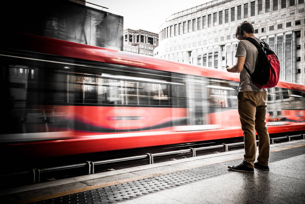 jeune homme attendant à la gare avec le flou de mouvement de train de vitesse - london england audio photos et images de collection