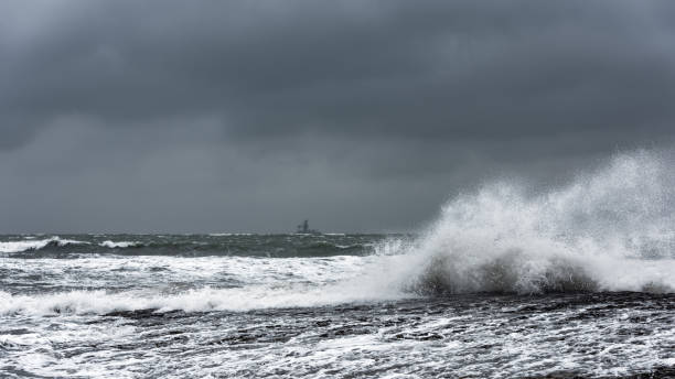 istock Splash of huge waves on a rocky shore 1136794799