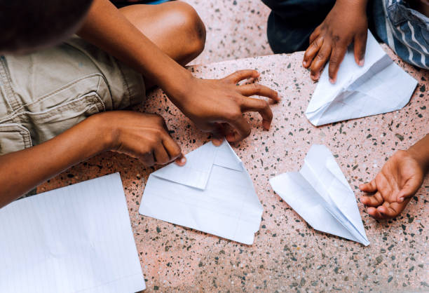 African boys building paper airplanes
