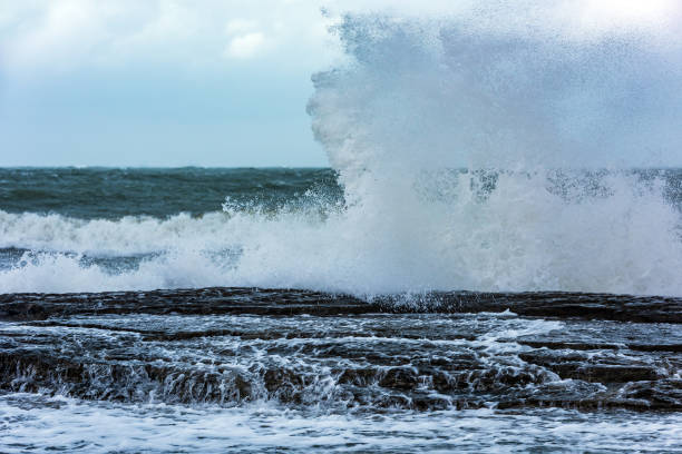 istock Splash of huge waves on a rocky shore 1136795089