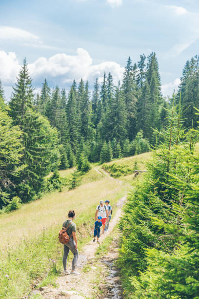 istock people walking by mountains forest with little boy. 1136798240