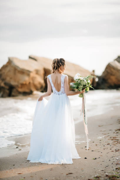 istock bride with a wedding bouquet on the shore  sea 1136799659
