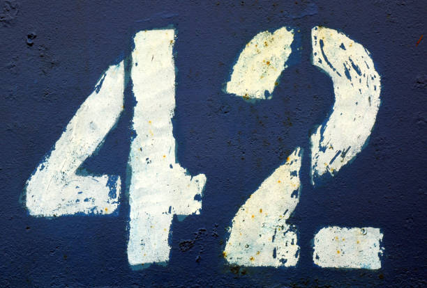 istock Number 42 in stencil on rusty navy blue metal wall. 1136800452