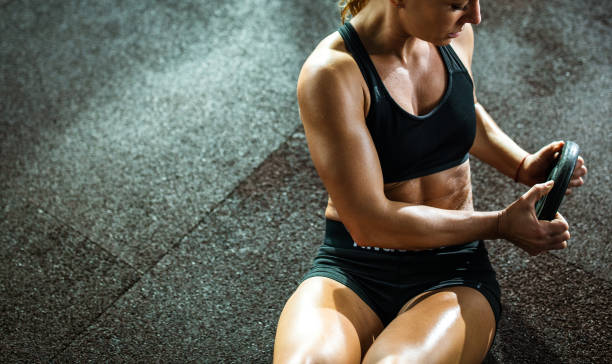 istock Muscular build female athlete doing abdominal exercises in a gym. 1136800497