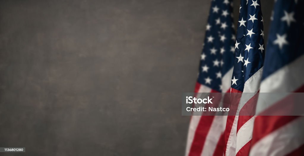 American flags over gray wal with copy space American flags over gray wall, 4th of july panoramic background with copy space American Flag Stock Photo