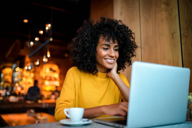 istock Smiling woman using laptop at the bar. 1136802760