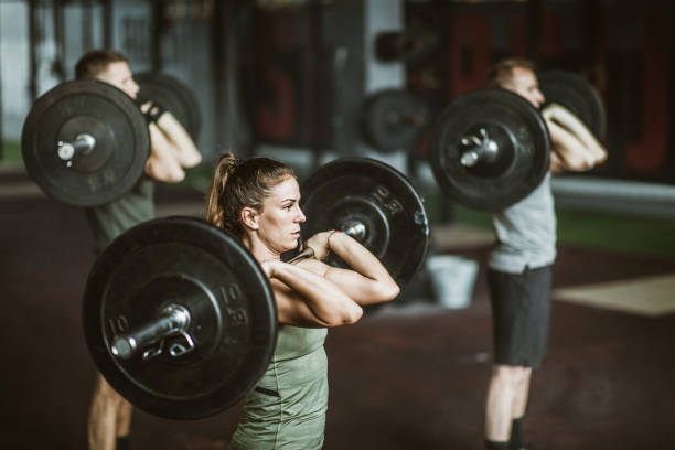 istock Athletic people having gym training with barbells in a gym. 1136803275