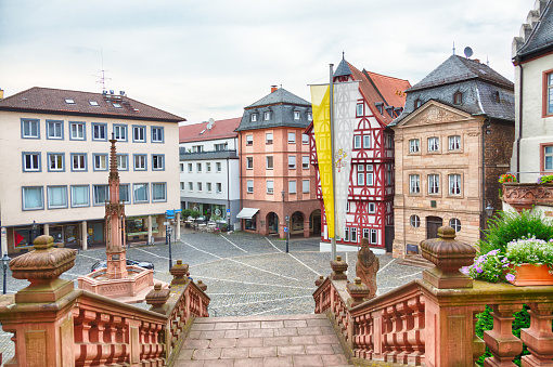 Aschaffenburg / Germany - June 2018. Twon square Stiftskirche platz with old buildings and timbered houses in front of the Saint Petrus and Alexander church in Aschaffenburg, Germany.