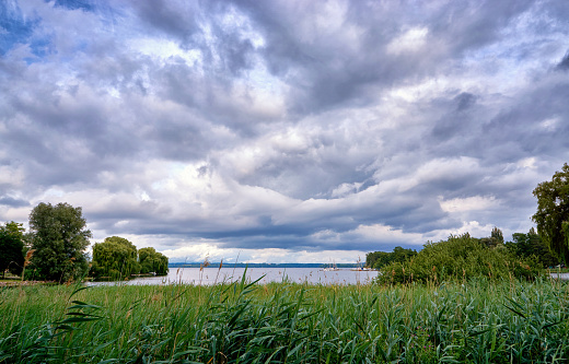 Dramatic clouds over the lake Schwerin with reed edge. Mecklenburg-Vorpommern, Germany