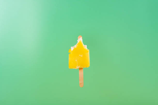 istock half eaten yellow popsicle on a light green background 1136805022