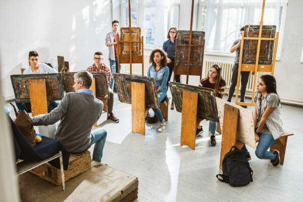 istock Large group of students having an art class with their teacher in a studio. 1136806202