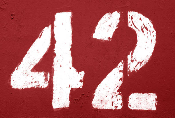 istock Number 42 in stencil on rusty metal wall in red tone. 1136806639