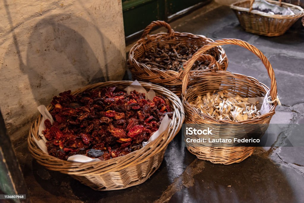 Baskets with dried aliments inside like dried tomatoes, mushrooms, raisins and roots Agaricus Stock Photo