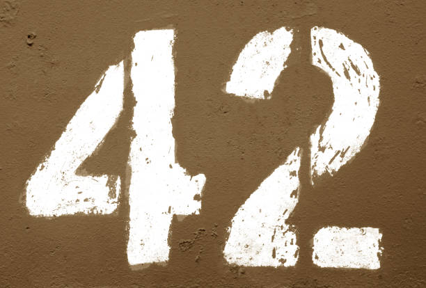 istock Number 42 in stencil on rusty metal wall in brown tone. 1136809111
