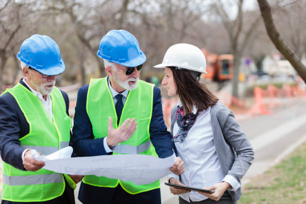 istock Mixed group of architects and business partners discussing project details on a construction site 1136814446