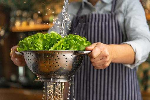 Woman rinsing salad