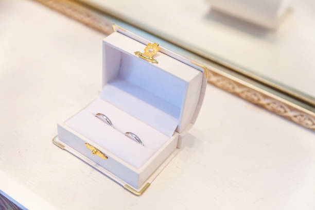 deux beaux anneaux de mariage sur la boîte de bijoux blanc sur le fond clair - traditional ceremony sign symbol wedding photos et images de collection