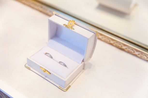 istock Two beautiful wedding rings on white jewelry box on light background 1136816247