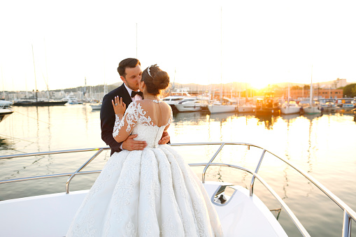 Beautiful wedding couple posing on boat at sea