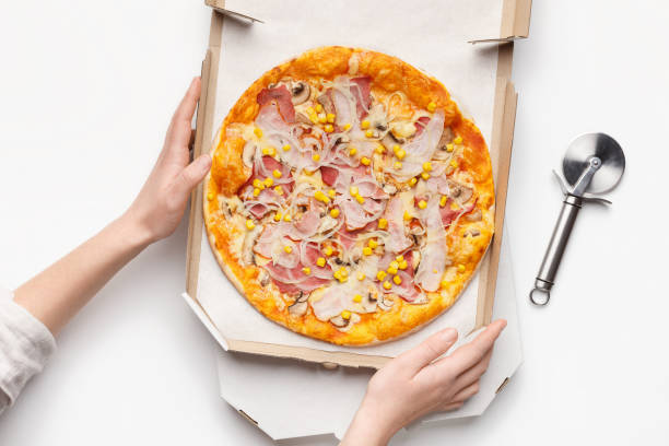 istock Woman holding cardboard box with pizza, top view 1136817040