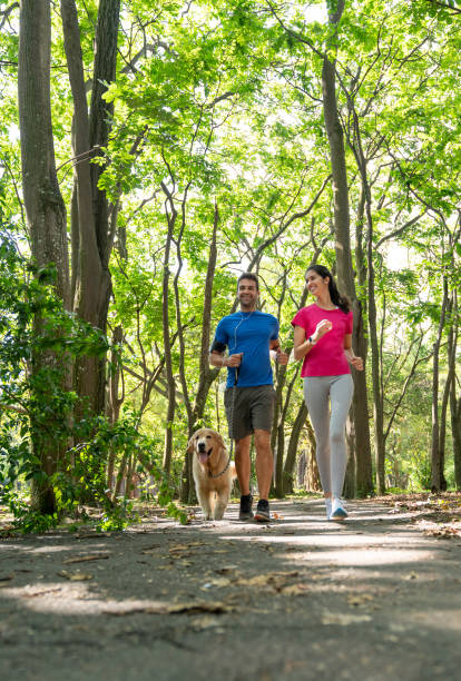 istock Happy couple running outdoors with their dog 1136817445