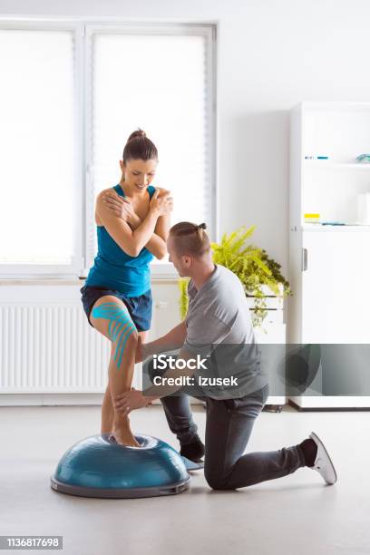 Young Woman Excercising With Physiotherapist Stock Photo - Download Image Now - Adhesive Tape, Physical Therapist, Adult