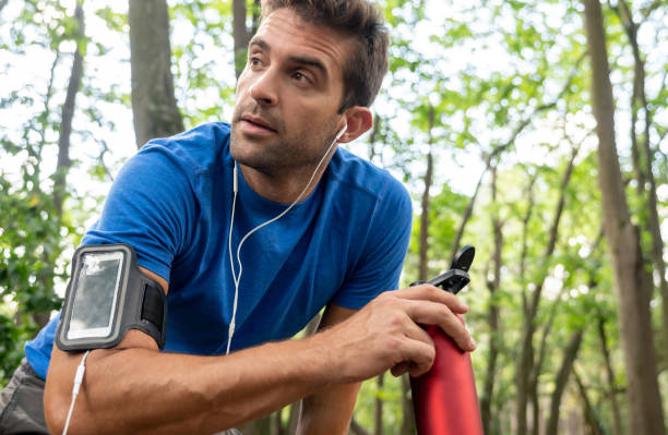 istock Man running and drinking water at the park 1136817875