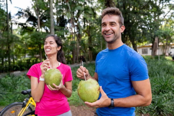 brazylijska para pijąca wodę kokosową po ćwiczeniach na świeżym powietrzu - instructor one person fruit drinking zdjęcia i obrazy z banku zdjęć